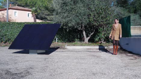 Forward-dolly-shot-towards-a-woman-plugging-in-her-new-solar-panel-in-her-back-garden