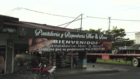 Traditional-sweet-bread-and-cake-bakery-Mar-and-Ross-in-the-outskirts-of-the-capital-with-busy-street,-Dolly-right-slow-motion-shot