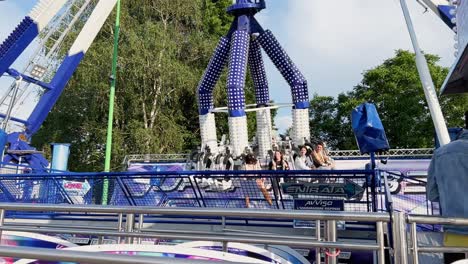 Verrückt-Schwingendes-Adrenalin-Frisbee-Karussell-Auf-Dem-Jahrmarkt-Mit-Verängstigten-Menschen