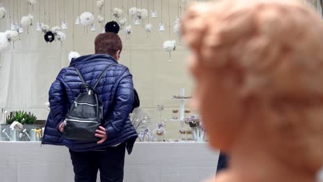 A-woman-taking-of-her-rucksack-in-front-of-a-stall-at-the-annual-flower-merket