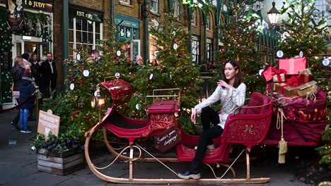 Modelo-Posando-Dentro-Del-Trineo-De-Santa,-Covent-Garden,-Londres,-Reino-Unido