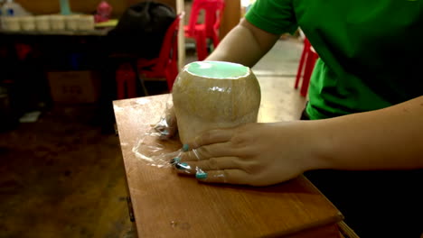 Mujer-Irreconocible-Envolviendo-Coco-Relleno-Con-Gelatina-De-Coco,-Comida-Callejera-Tradicional-Tailandesa-Hecha-Con-Pulpa-De-Coco-Y-Gelatina-De-Agua