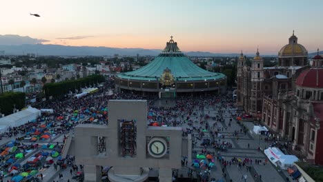 Vista-Aérea-Sobre-El-Carrillón-Hacia-La-Basílica-De-Nuestra-Señora-De-Guadalupe,-Peregrinación-Virgen-Día-Noche-En-México