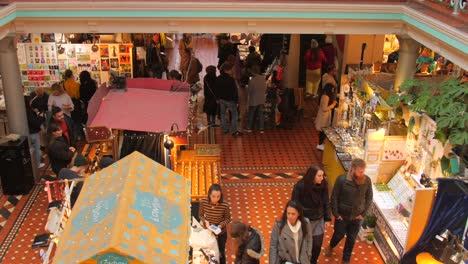 People-walking-down-the-shops-of-Camden-High-Street-market-in-Camden-Lock-or-Camden-Town-in-London,-England,-United-Kingdom