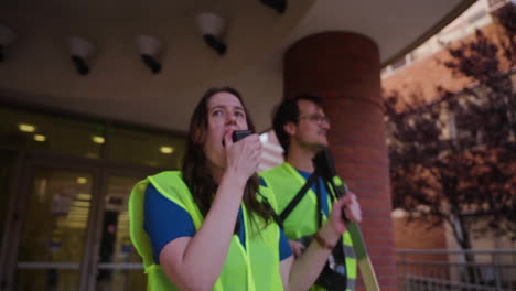 Eine-Junge-Frau-Spricht-Leidenschaftlich-In-Ein-Megaphon-Zu-Einer-Menge-Von-Arbeitern-Am-Streikpostenstreikposten-Für-Akademische-Arbeiter-Der-Uc-In-Ucla