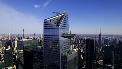 Aerial-view-in-front-of-the-30-Hudson-Yards-skyscraper,-golden-hour-in-New-York,-USA---Ascending,-drone-shot