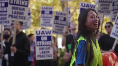 Una-Joven-Golpea-Un-Tambor-Y-Sonríe-Mientras-Dirige-Un-Grupo-De-Trabajadores-Académicos-De-La-Uc-En-Huelga-En-La-Ucla