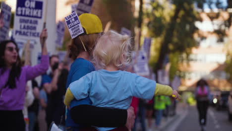 Una-Mujer-Joven-Que-Sostiene-A-Un-Bebé-Lidera-Una-Huelga-De-Trabajadores-Académicos-De-La-Uc-En-La-Ucla