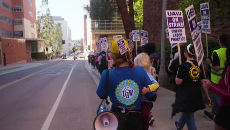 Una-Mujer-Joven-Con-Un-Bebé-Y-Un-Megáfono-Encabeza-Una-Fila-De-Trabajadores-Académicos-De-La-Uc-En-Huelga-En-La-Ucla