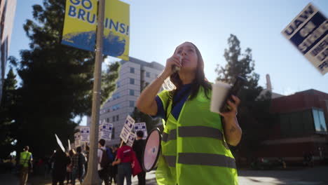 Eine-Junge-Frau-Spricht-Zur-Goldenen-Stunde-In-Ein-Megaphon-Am-Streikpostenstreikposten-Der-Uc-Akademischen-Arbeiter-In-Ucla