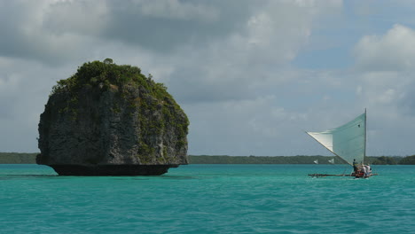 Indígenas-Que-Llevan-A-Los-Turistas-En-Una-Tradicional-Canoa-De-Veleros-En-La-Bahía-De-Uoi,-Isla-De-Los-Pinos