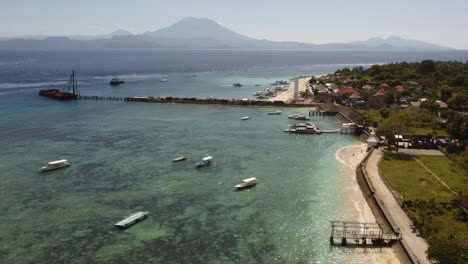 AERIAL:-Drone-shot-showing-a-boat-dock-with-Mount-Batur-in-the-backgound