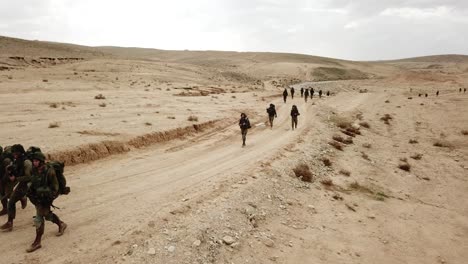 Disparo-De-Drones-De-Tropas-De-Soldados-De-Las-FDI-Caminando-Hacia-Adelante-Durante-Una-Operación-Militar-En-El-Desierto