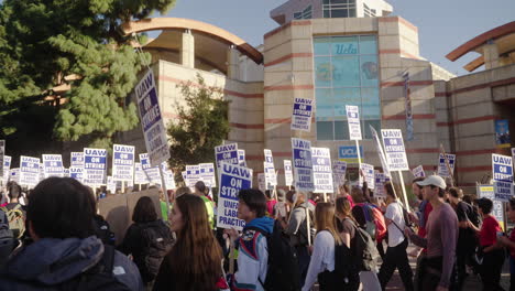 Una-Gran-Multitud-De-Trabajadores-Académicos-En-Huelga-En-El-Campus-De-Ucla-Con-Un-Cartel-De-Fútbol-En-El-Fondo