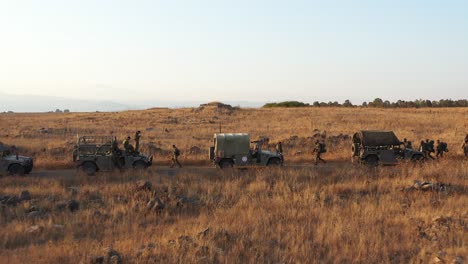 Drohnenansicht-Truppen-Militärfahrzeuge,-Die-Während-Kriegsspielen-Auf-Trockenem-Grasfeld-Aufgereiht-Sind