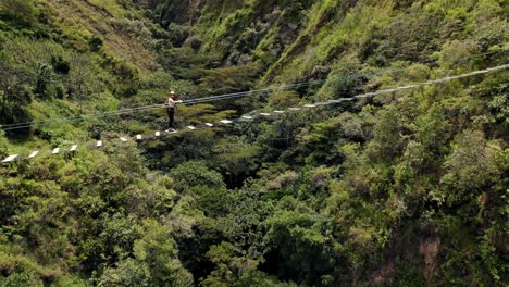 Tapfere-Person-Mit-Helm,-Die-Eine-Tibetische-Seilbrücke-über-Das-Peruanische-Amazonische-Tal-Geht-Und-überquert