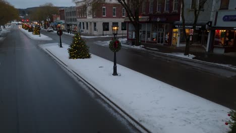 Hermosa-Toma-Aérea-Cinematográfica-Baja-De-árboles-De-Navidad-Iluminados-Que-Bordean-La-Calle-Principal-En-Wellsboro-Pa