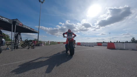 El-Dron-Fpv-Rodea-Al-Enérgico-Motociclista-Mientras-Hacen-Caballitos-Desde-La-Pista-De-Boxes-Para-Unirse-Al-Circuito-De-Carreras