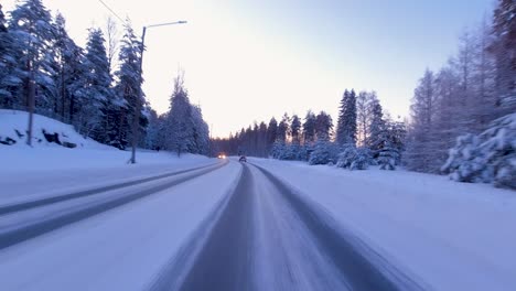 POV-Schuss,-Der-Durch-Eine-Landstraße-Fährt,-Die-Von-Schneebedeckten-Bäumen-Umgeben-Ist