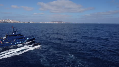 Aerial-shot-of-a-police-patrol-next-to-one-of-the-boats-that-pass-by