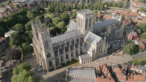 Hohe-Luftdrohnenaufnahme,-Die-über-Die-Berühmte-Ikonische-Yorker-Münsterkathedrale-Fliegt,-Mit-Touristen,-Die-An-Einem-Sonnigen-Tag-In-Nord-Yorkshire,-Vereinigtes-Königreich,-Spazieren-Gehen