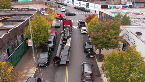 Brooklyn-Nyc-Usa,-Lkw-Und-Langer-Anhänger-Mit-Stahlkonstruktionen,-Die-Sich-Auf-Der-Straße-Rückwärts-Bewegen,-Drohne-Erschossen