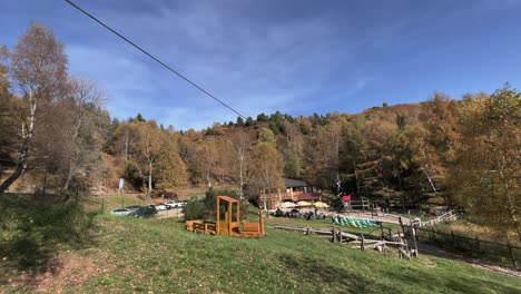 Mutige-Kinder-Haben-Spaß-Mit-Der-Seilrutsche-Im-Seilabenteuerpark,-Wald-Im-Hintergrund-Und-Himmel-Für-Kopierraum