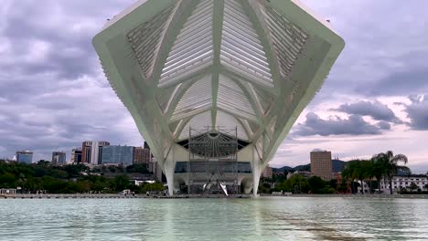 Architecture-of-the-Museum-of-Tomorrow-in-Brazil-with-scaffolding-for-maintenance-of-the-contemporary-sustainable-design-and-wrinkles-of-the-wind-in-the-pond-in-front-of-the-impressive-facade