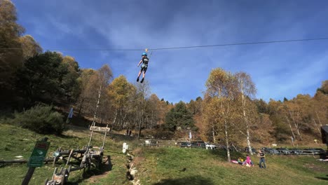 Kinder-Genießen-Das-Fliegen-An-Der-Seilrutsche-Im-Seilabenteuerpark,-Wald-Im-Hintergrund-Und-Himmel-Für-Kopierraum