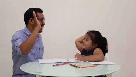 Indonesia---Dec-18,-2022-:-asian-little-girl-coloring-a-book-with-his-dad