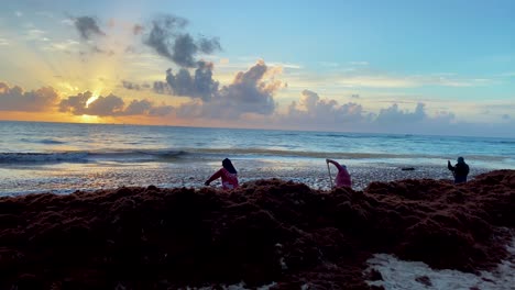 Trabajadores-Locales-Quitando-Algas-Sargassum-En-La-Playa-De-Playa-Del-Carmen-Al-Atardecer-En-México