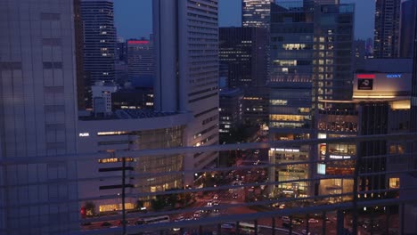 Skyline-of-Osaka-at-night-in-the-center-of-Umeda,-Establishing-Pan