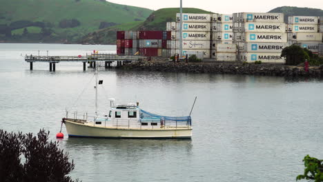 Boot-Vor-Anker-Im-Hafen-Von-Chalmers,-Versandbehälter-Im-Hintergrund