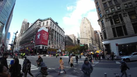 NYC-USA,-Foot-Traffic-on-34th-and-6th-Avenue-in-Midtown-Manhattan,-People-on-Crosswalk,-Buildings-and-Cars