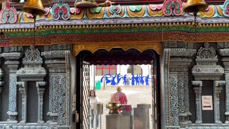 Tilt-down-view-of-devotees-praying-outside-Sri-Krishnan-Temple,-a-Hindu-Temple-at-Waterloo-Street,-Bugis,-Singapore