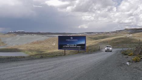 Truck-drives-past-road-sign-to-Letseng-Diamond-Mine-in-Lesotho,-Africa