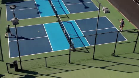 Juego-De-Pickleball,-Partido-De-Individuales-En-La-Cancha-Exterior,-Dos-Hombres-Jugando,-Vista-Aérea-Estática