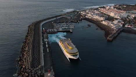 Fantástica-Toma-Aérea-De-Un-Ferry-Saliendo-Del-Puerto-De-Agaete-Durante-La-Puesta-De-Sol