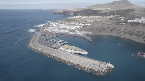 Fantástica-Toma-Aérea-A-Media-Distancia-Y-En-órbita-Sobre-El-Ferry-Atracado-En-El-Puerto-De-Agaete-En-Un-Día-Soleado