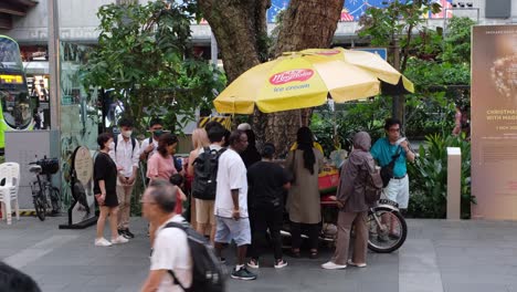 Brand-of-Ice-cream-called-Walls--man-selling-ice-cream-along-the-street-with-people-wanting-to-buy