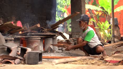 Un-Hombre-De-Mediana-Edad-Está-Agregando-Combustible-Para-Quemar-Cerámica-O-Cerámica-De-Arcilla-Para-Fortalecer-El-Producto