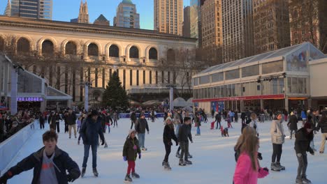 Gente-Patinando-En-La-Pista-De-Patinaje-Sobre-Hielo-De-Bryant-Park-Durante-El-Invierno-En-La-Ciudad-De-Nueva-York,-Nueva-York