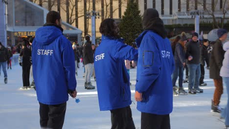 Personal-De-Patinaje-Sobre-Hielo-Con-Uniformes-Azules-Y-Patinadores-En-La-Pista-Durante-El-Invierno-En-Nueva-York,-Ee.uu.