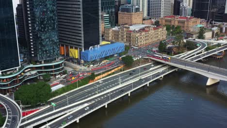 Desarrollo-De-La-Ciudad-De-Brisbane,-Vista-Aérea-Con-Vistas-A-La-Autopista-Del-Río-M3-De-La-Autopista-Pacífica,-La-Inclinación-Hacia-Arriba-Revela-El-Edificio-Del-Patrimonio-Del-Casino-Del-Tesoro-Y-La-Construcción-Del-Muelle-De-La-Reina-En-Progreso-En-El-Centro