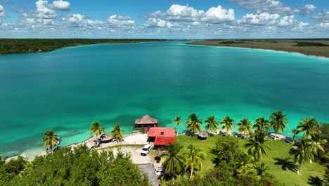 Vista-Aérea-De-Un-Resort-Paradisíaco-En-La-Soleada-Laguna-De-Bacalar,-En-México