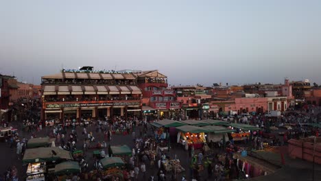 Marruecos,-Marrakech,-Girando-Video-De-Lapso-De-Tiempo-Al-Atardecer-Con-El-Mercado-Ocupado-En-El-Fondo