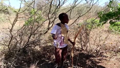 Close-up-of-proud-African-Hadzabe-tribe-boy-for-hunting-a-rat-to-eat-in-the-savannah-bush