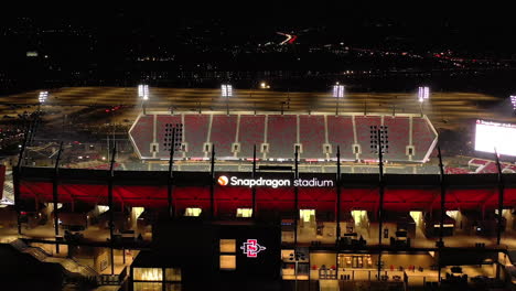 Estadio-Snapdragon-En-La-Noche-Con-Luces-De-Inundación-Encendidas,-Tiro-De-Drones