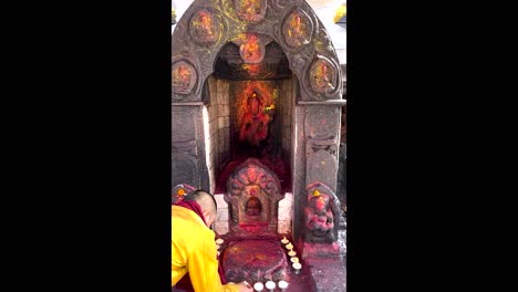 A-Buddhist-monk-lights-candles-as-an-offering-to-the-Gods-before-praying-at-a-Buddhist-temple-in-Nepal