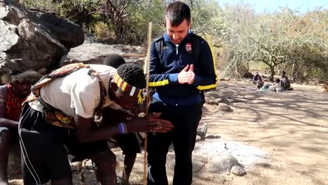 Hadzabe-tribe-chief-showing-tourist-how-to-make-fire-with-wooden-stick-and-metal